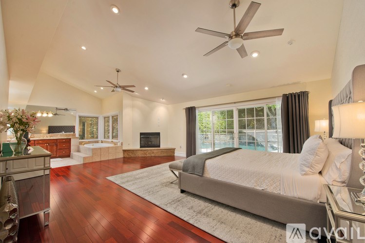 A bedroom with a large bed and a ceiling fan.