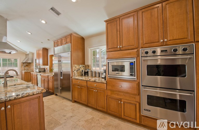 A kitchen with wooden cabinets and stainless steel appliances.