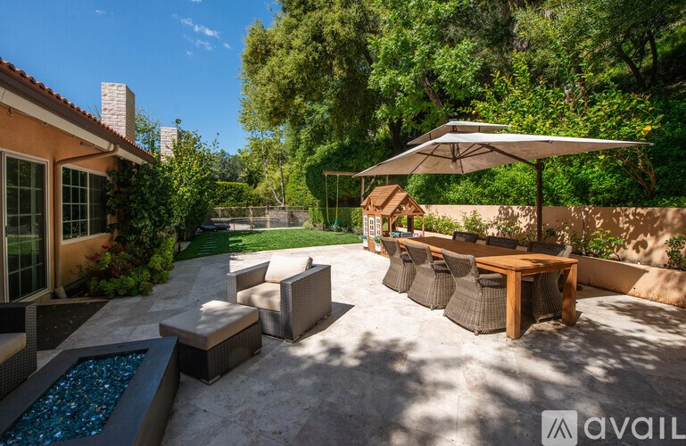 A patio with a table and chairs and a fountain.