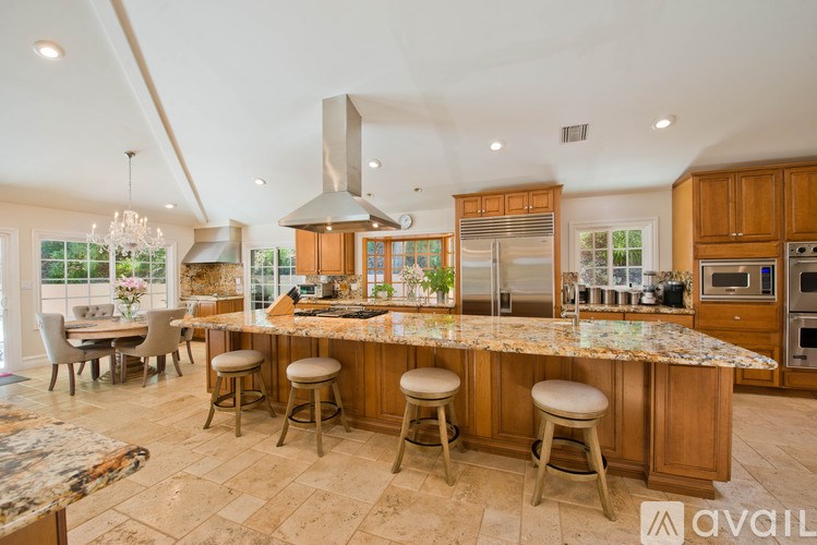 A kitchen with a marble countertop and wooden cabinets.