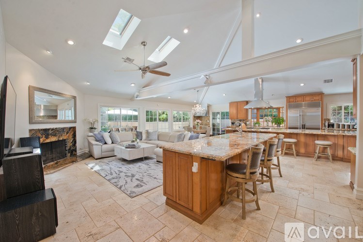 A spacious kitchen and living room with a central island and a fireplace.