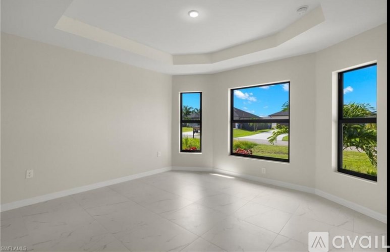 Three flat screen TVs are mounted on a wall in a spacious room.