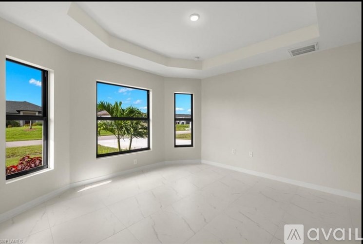 Three windows in a room with a white floor and walls.