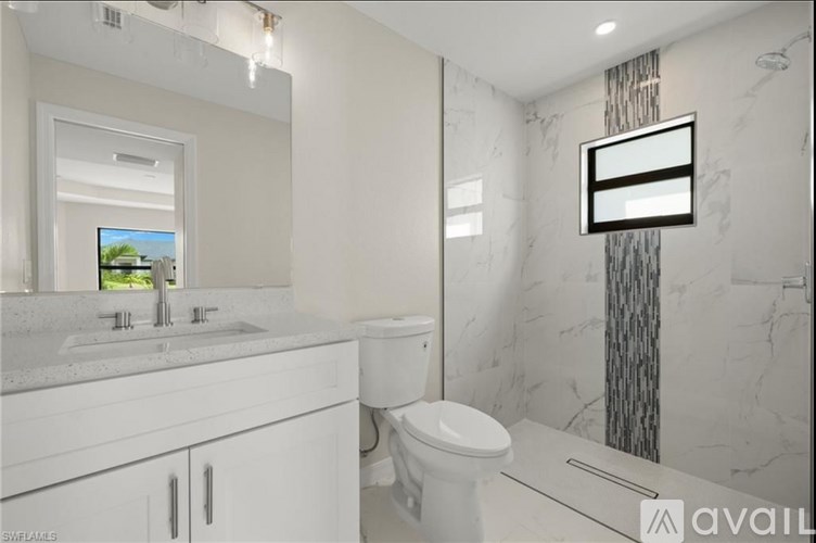 A bathroom with a white toilet, sink, and mirror.