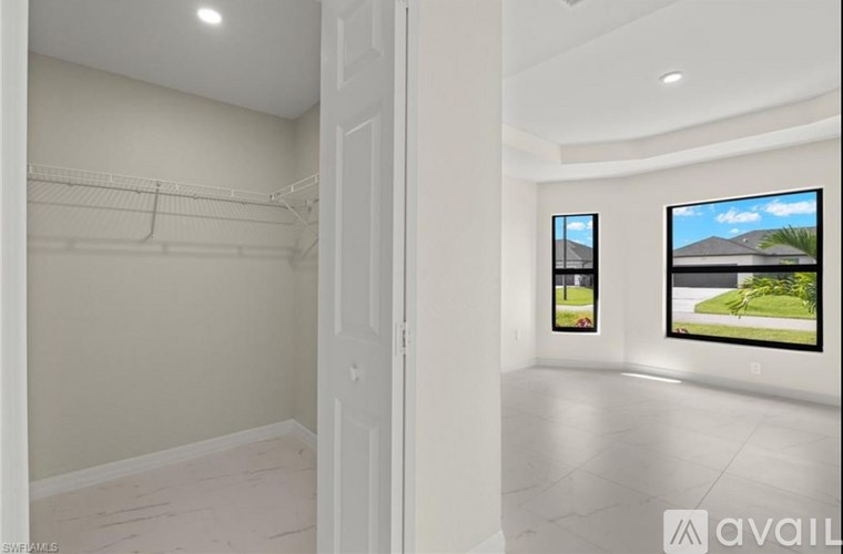 A white room with a door and a wall-mounted TV displaying a landscape scene.