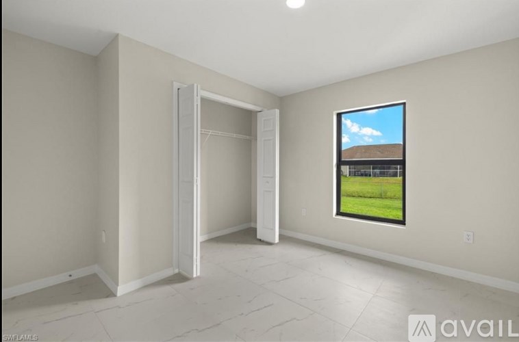 A room with a large window and a door is available for rent.