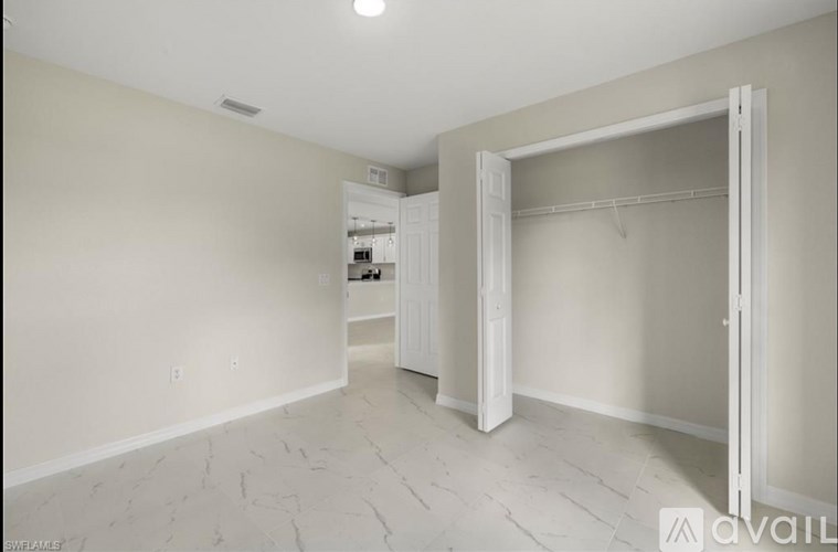 A spacious room with a marble floor and a walk-in closet.