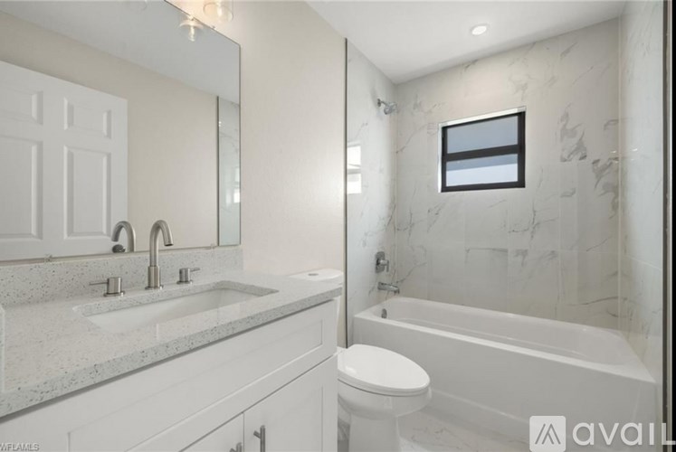 A bathroom with a marble wall and a white toilet.