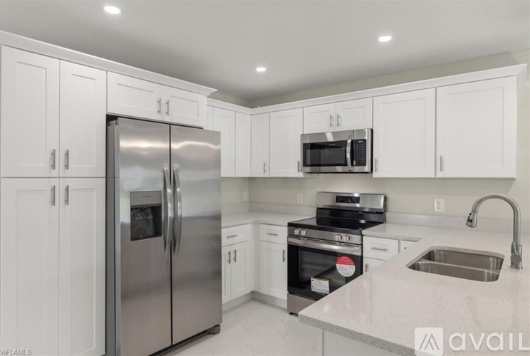 A kitchen with white cabinets and stainless steel appliances.