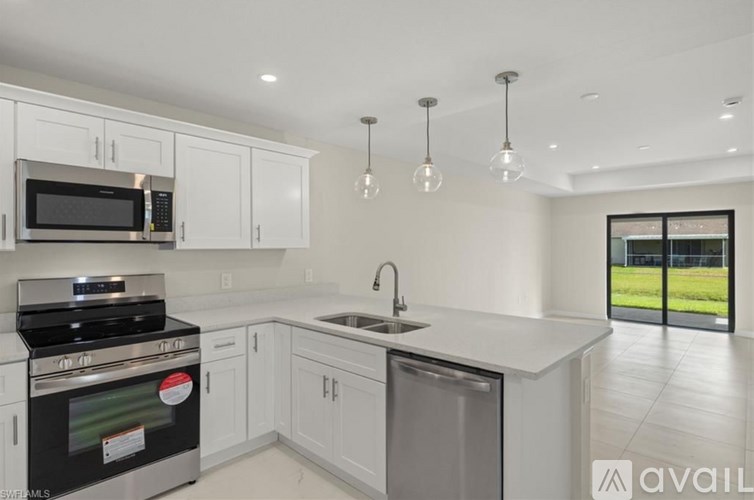 A modern kitchen with white cabinets and a black stove top oven.