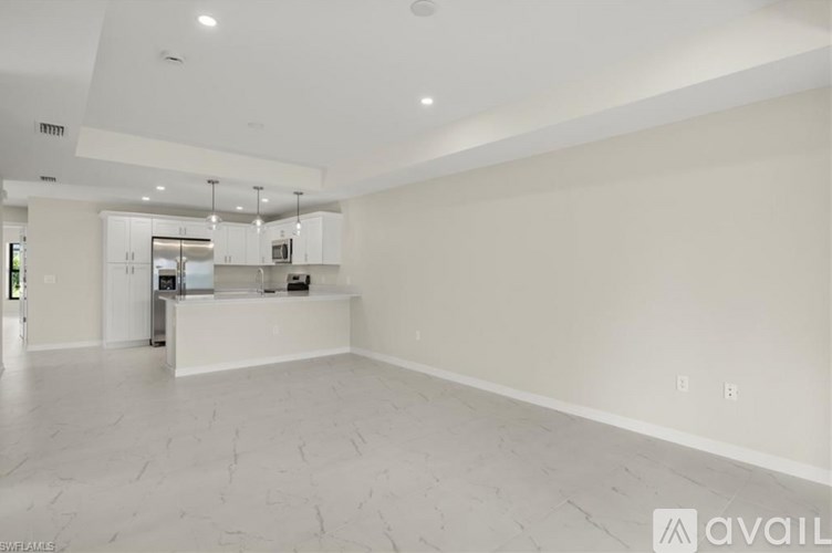 A spacious kitchen with white cabinets and a countertop.
