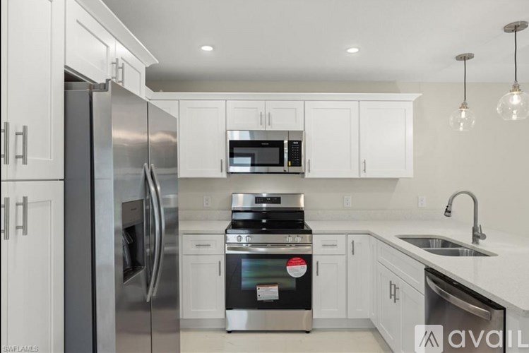 A modern kitchen with stainless steel appliances and white cabinets.