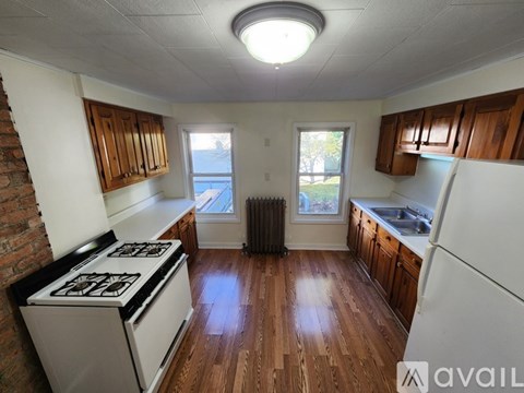 A kitchen with wooden floors and white appliances.