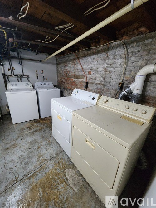 A dirty basement with a washer and dryer.