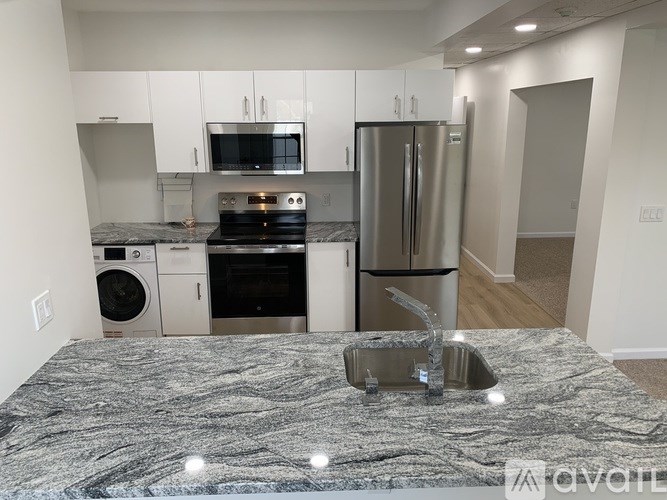 A kitchen with a granite countertop and stainless steel appliances.