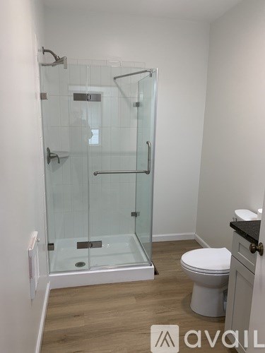 A bathroom with a toilet, sink, and walk-in shower.