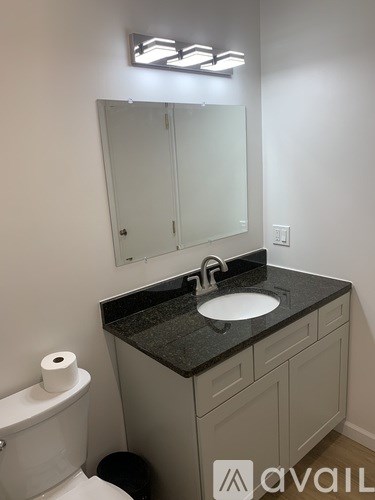 A bathroom with a sink, mirror, and toilet.