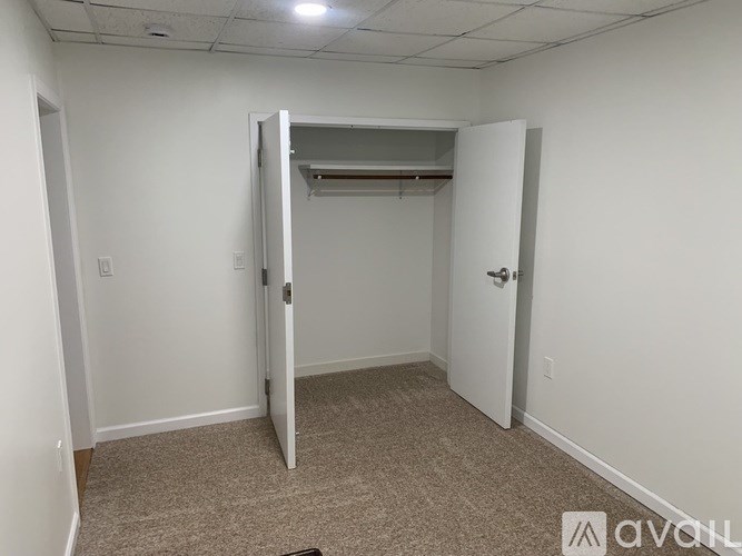 A room with a carpeted floor and a white door.