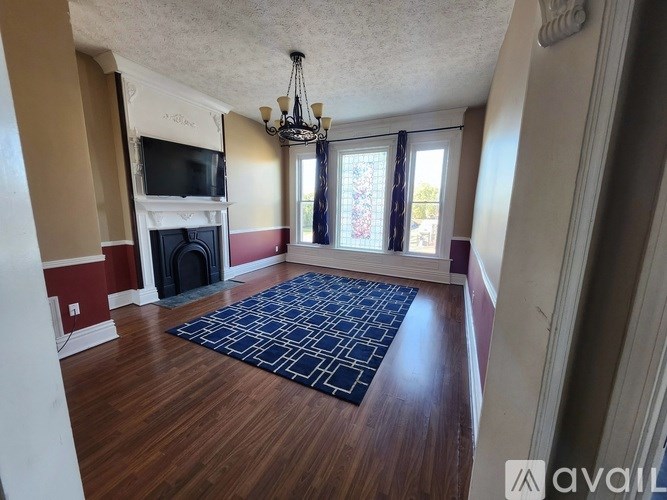 A living room with a fireplace and a chandelier.