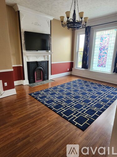 A room with a chandelier, a window, and a picture on the wall.