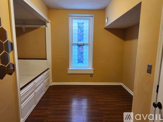 A kitchen with a yellow wall and a wooden table.
