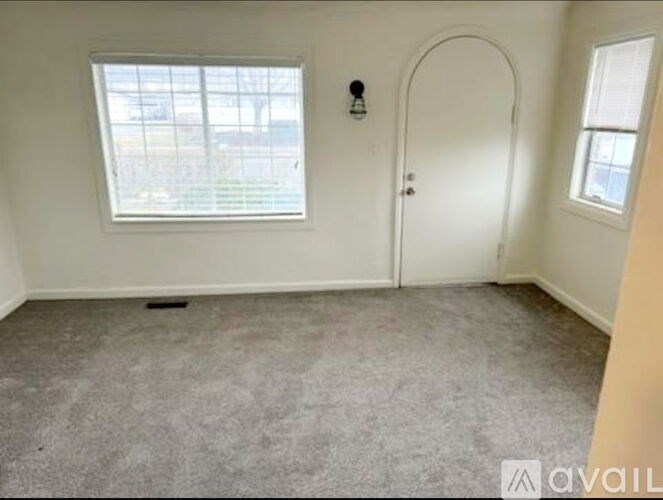 A room with a window and a door is available for rent.