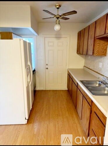 A kitchen with wooden cabinets and a white refrigerator.