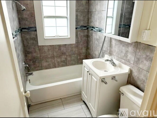 A bathroom with a tub, sink, and toilet.