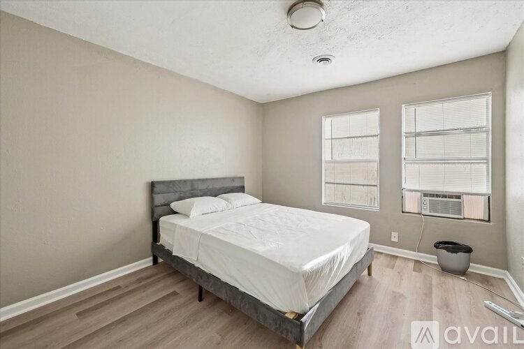 A bedroom with a bed, window, and a fan.