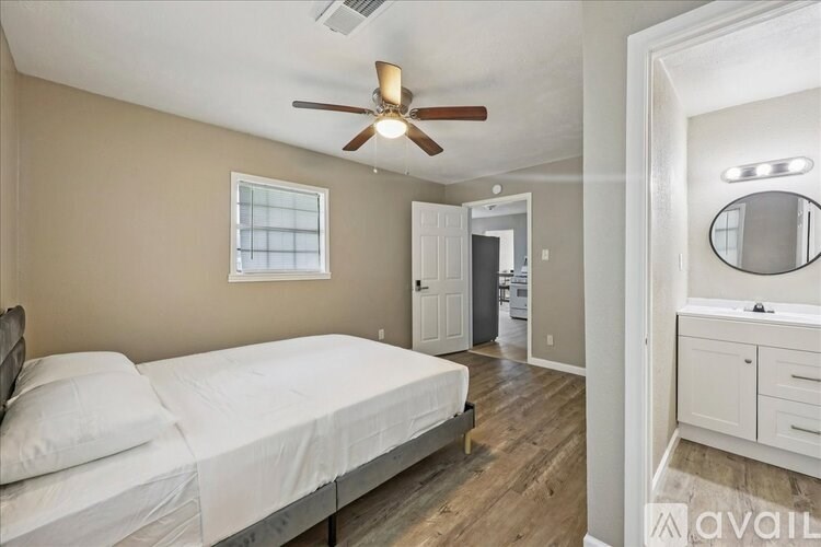 A bedroom with a bed, dresser, and mirror.