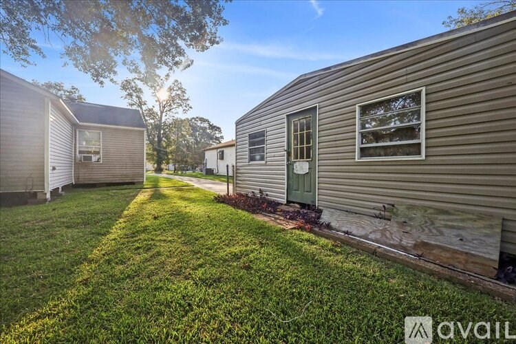A sunny day at a grassy yard with a few houses.