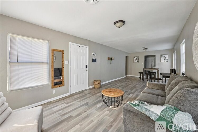 A living room with a grey couch and a wooden coffee table.