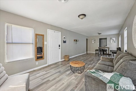 A living room with a grey couch and a wooden coffee table.