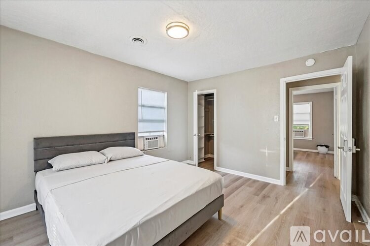 A bedroom with a large bed and a window.