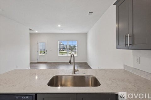 A modern kitchen with a stainless steel sink and granite countertops.
