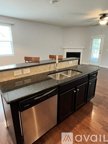 A kitchen with a black counter top and stainless steel dishwasher.