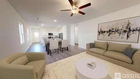 A living room with a beige couch, a coffee table, and a large abstract painting on the wall.