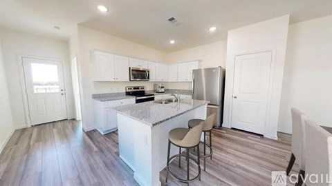 A kitchen with a granite countertop and stainless steel appliances.