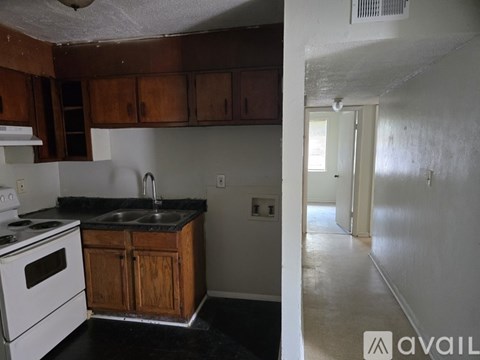 A kitchen with a white stove and wooden cabinets.