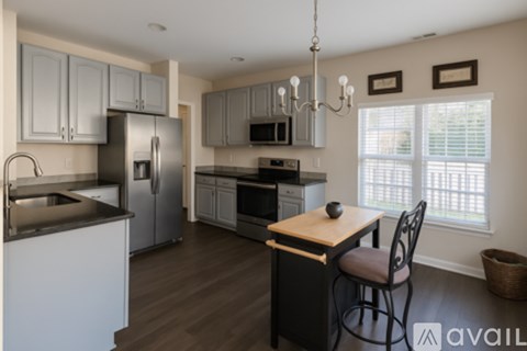 A kitchen with a wooden island and a refrigerator.