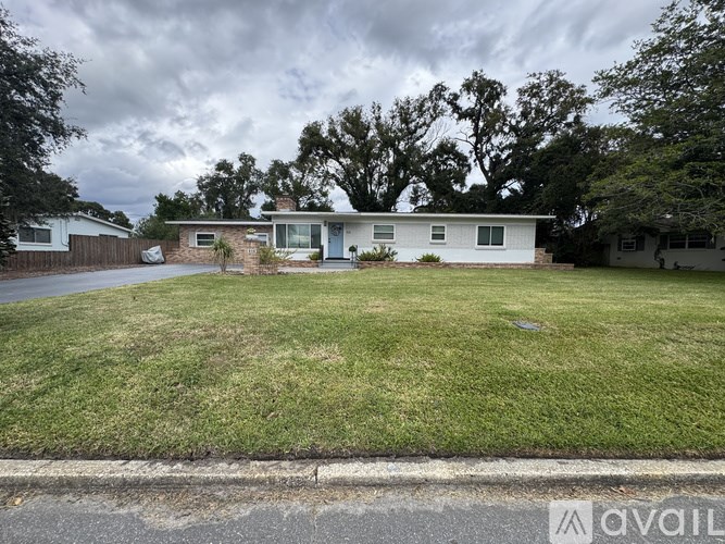 A house with a white exterior and a green lawn is shown in the image.