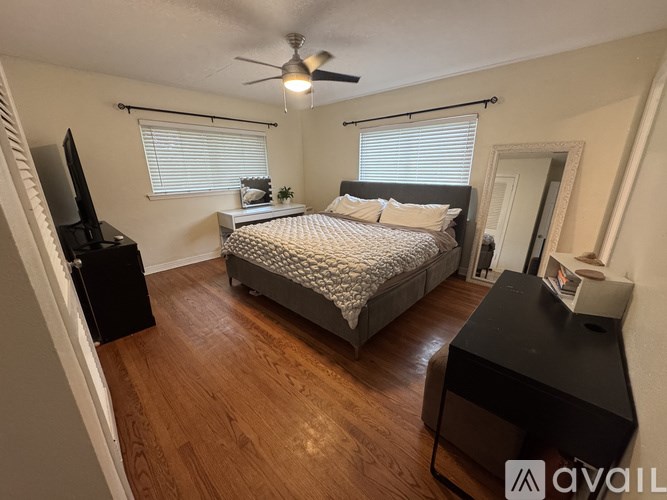 A bedroom with a bed, dresser, and television.