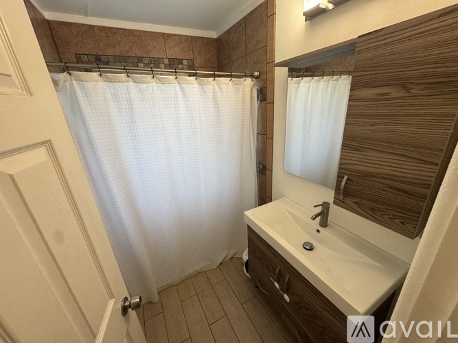 A bathroom with a white shower curtain and a white sink.