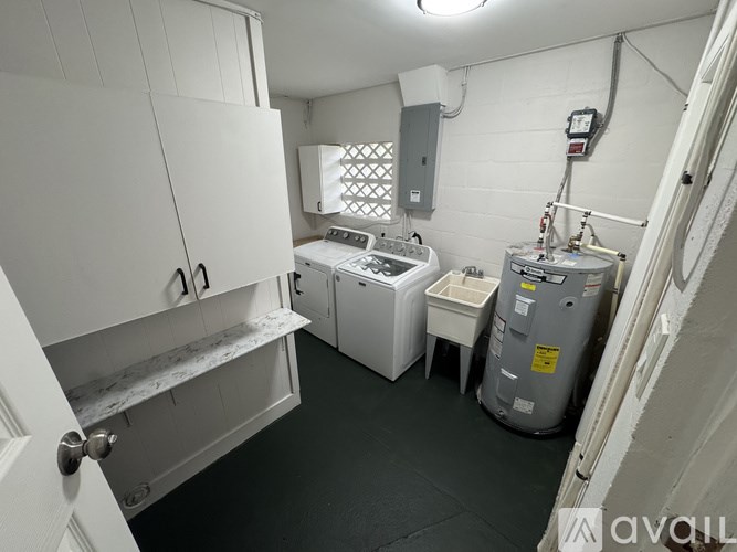 A small, white-walled laundry room with a washer and dryer.
