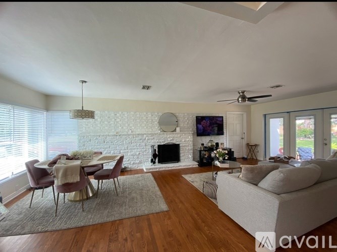 A living room with a fireplace and a television on the wall.