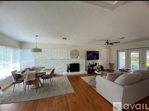 A living room with a fireplace and a television on the wall.
