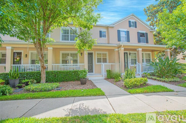A two-story house with a front porch and a white picket fence.