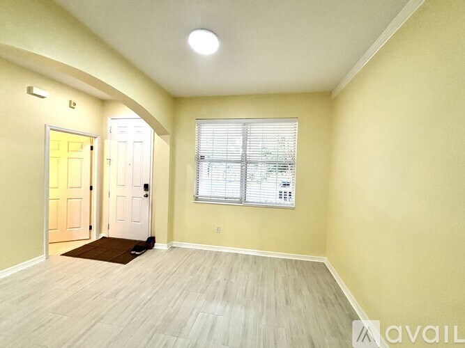 A room with a door, window, and a rug on the floor.