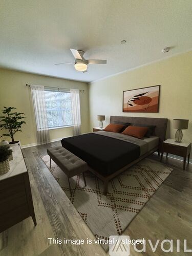 A bedroom with a bed, nightstand, and a plant.