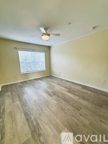A room with wooden flooring and a ceiling fan.